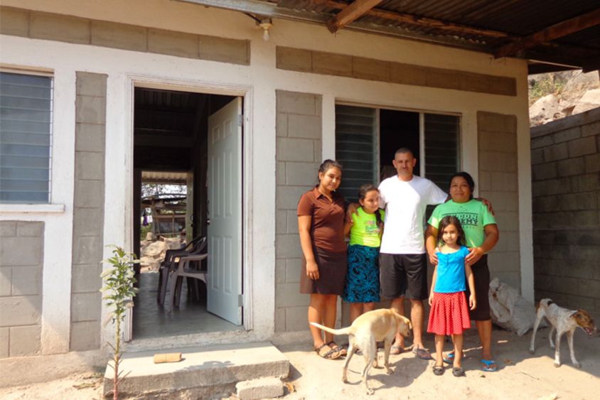 Familia con sus perros afuera de su casa. Inversión Social e inclusión - Banco Interamericano de Desarrollo - BID 