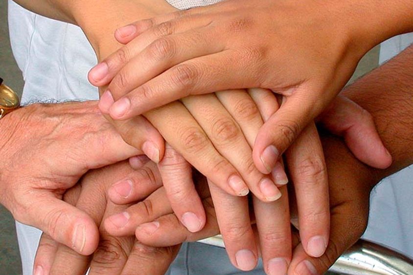 a close-up of several hands stacked on top of each other