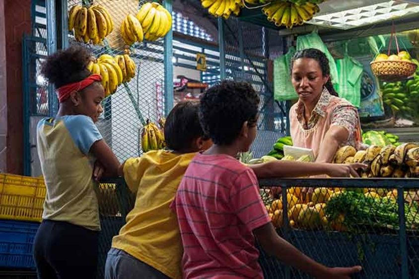 Children standing in a fruit stand. Information - Inter-American Development Bank - IDB