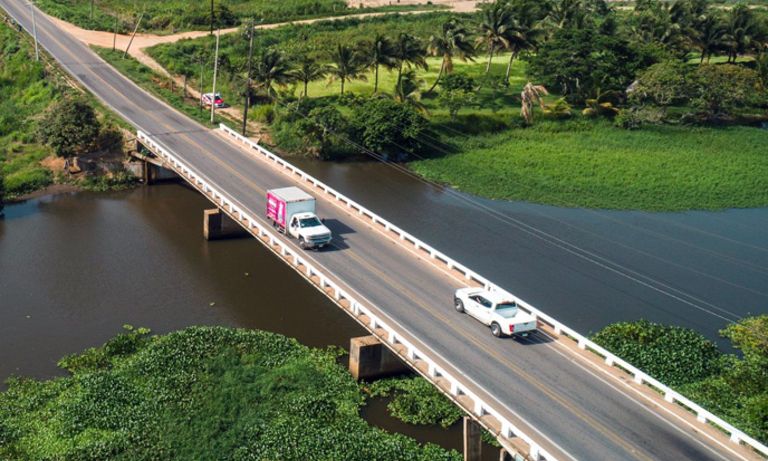 Vehículos transitando un puente que pasa sobre un río. Transporte y Desarrollo - Banco Interamericano de Desarrollo - BID