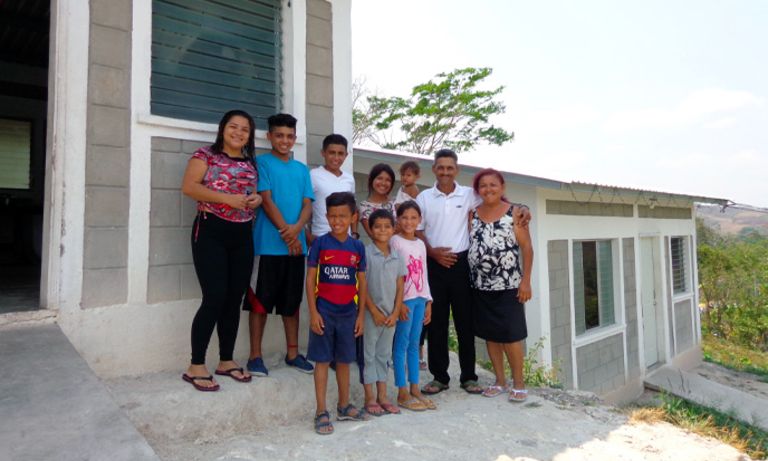 Una familia numerosa reunida en la entrada de su casa. Desarrollo social - Banco Interamericano de Desarrollo - BID 