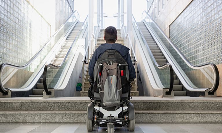 Una persona en silla de ruedas de espaldas mirando unas escaleras. Equidad e inclusión - Banco Interamericano de Desarrollo - BID 