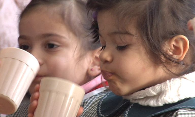 Close-up of a couple of young childs drinking from a white cup. Rural development - Inter-American Development Bank - IDB