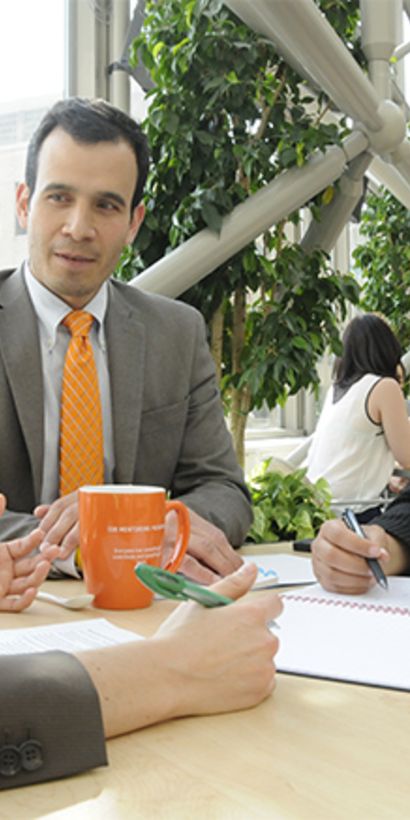 Tres profesionales sentados en una mesa dialogando. Empleos - Banco Interamericano de Desarrollo - BID