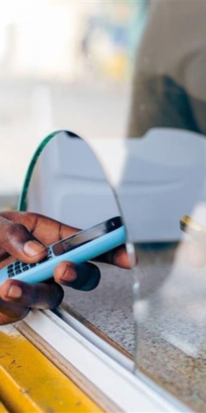 Two hands holding two mobile phones in the middle of a window - Inter American Development Bank - Migration