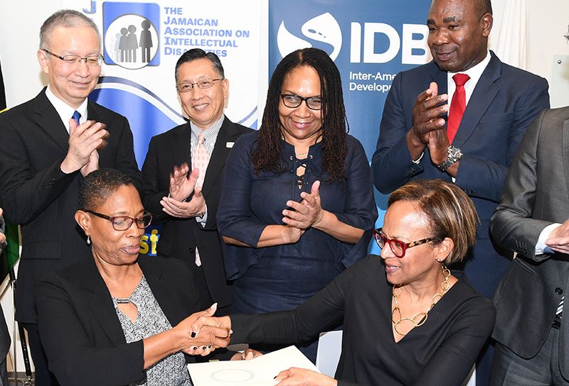 Profesionales apretando manos en la firma de un acuerdo. Desarrollo profesional - Banco Interamericano de Desarrollo - BID